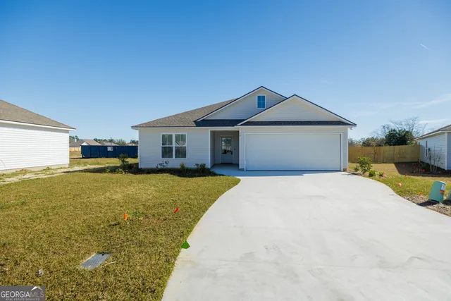 a front view of a house with a garden and yard