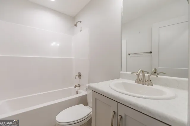 a bathroom with a granite countertop toilet a sink and a bathtub