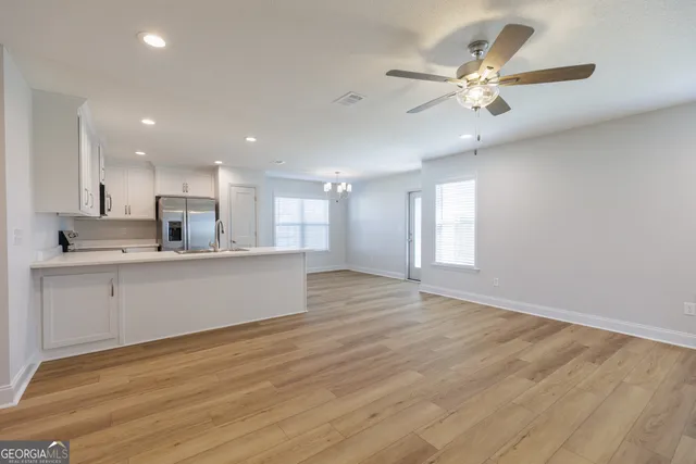 a view of kitchen with kitchen island stainless steel appliances sink and cabinets