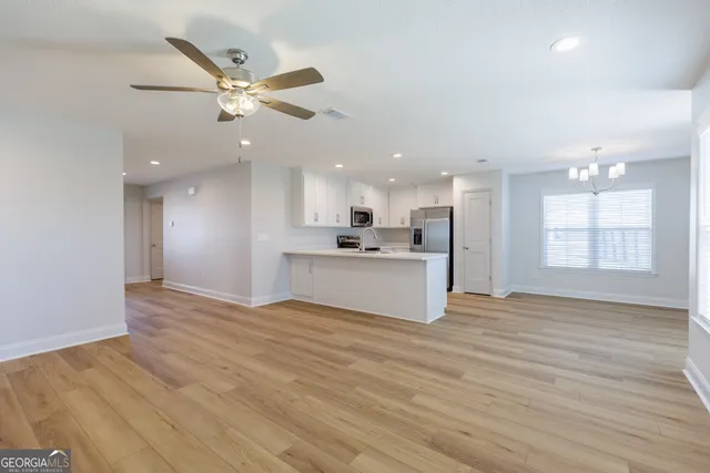 a view of a kitchen with a sink and wooden floor