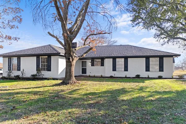 a view of a house with a big yard and large tree