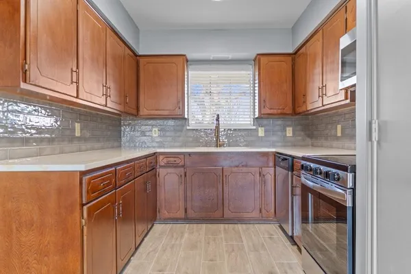 a kitchen with stainless steel appliances granite countertop a sink stove and cabinets