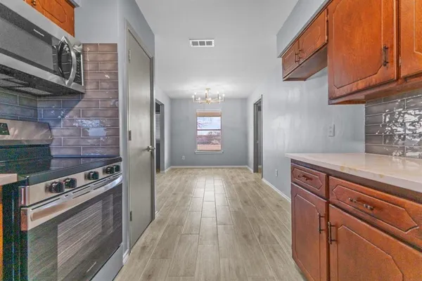 a kitchen with wooden floors and appliances
