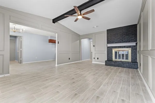 a view of an empty room with a fireplace and a window