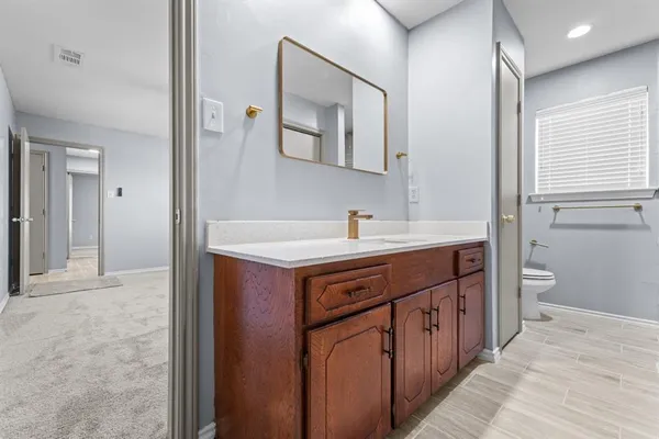 a bathroom with a double vanity sink mirror and toilet
