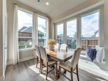 a dining room with furniture window and wooden floor