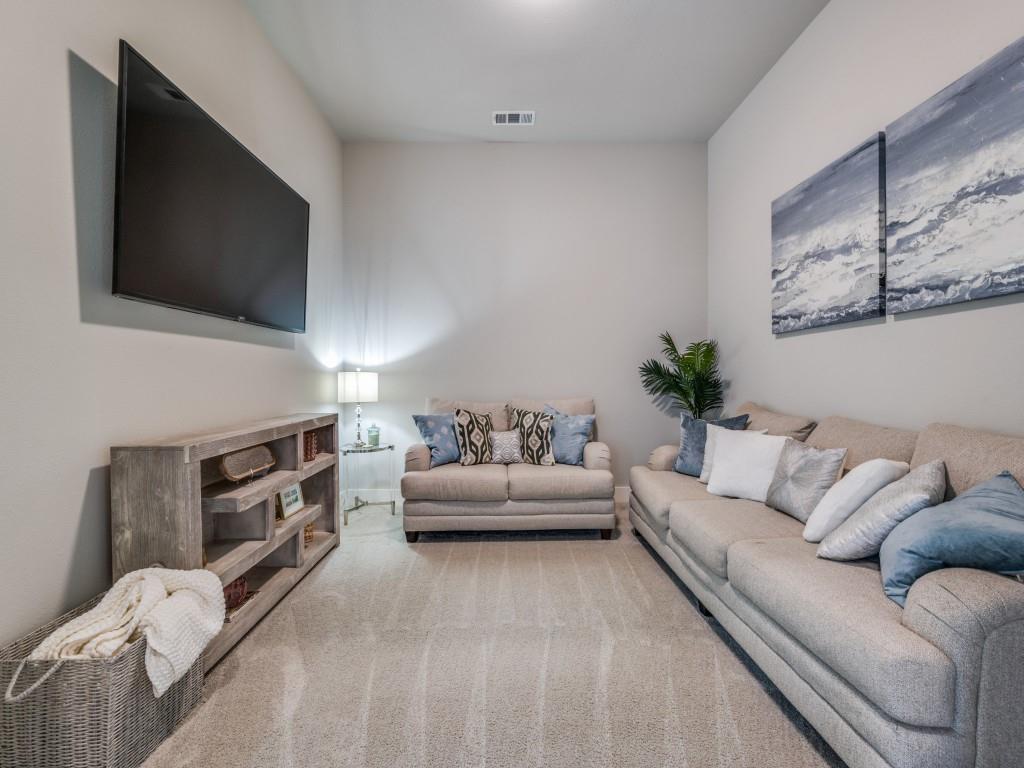 2724 Eccleston Street Celina, TX 75009 - Photo 13 of 29 a living room with furniture a flat screen tv and a fireplace