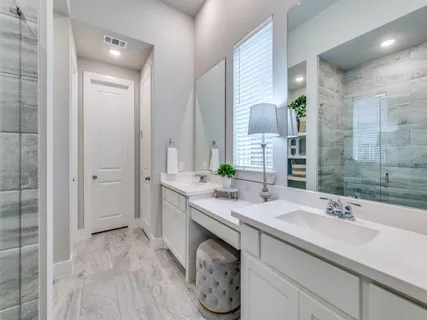a spacious bathroom with a double vanity sink a mirror and a shower