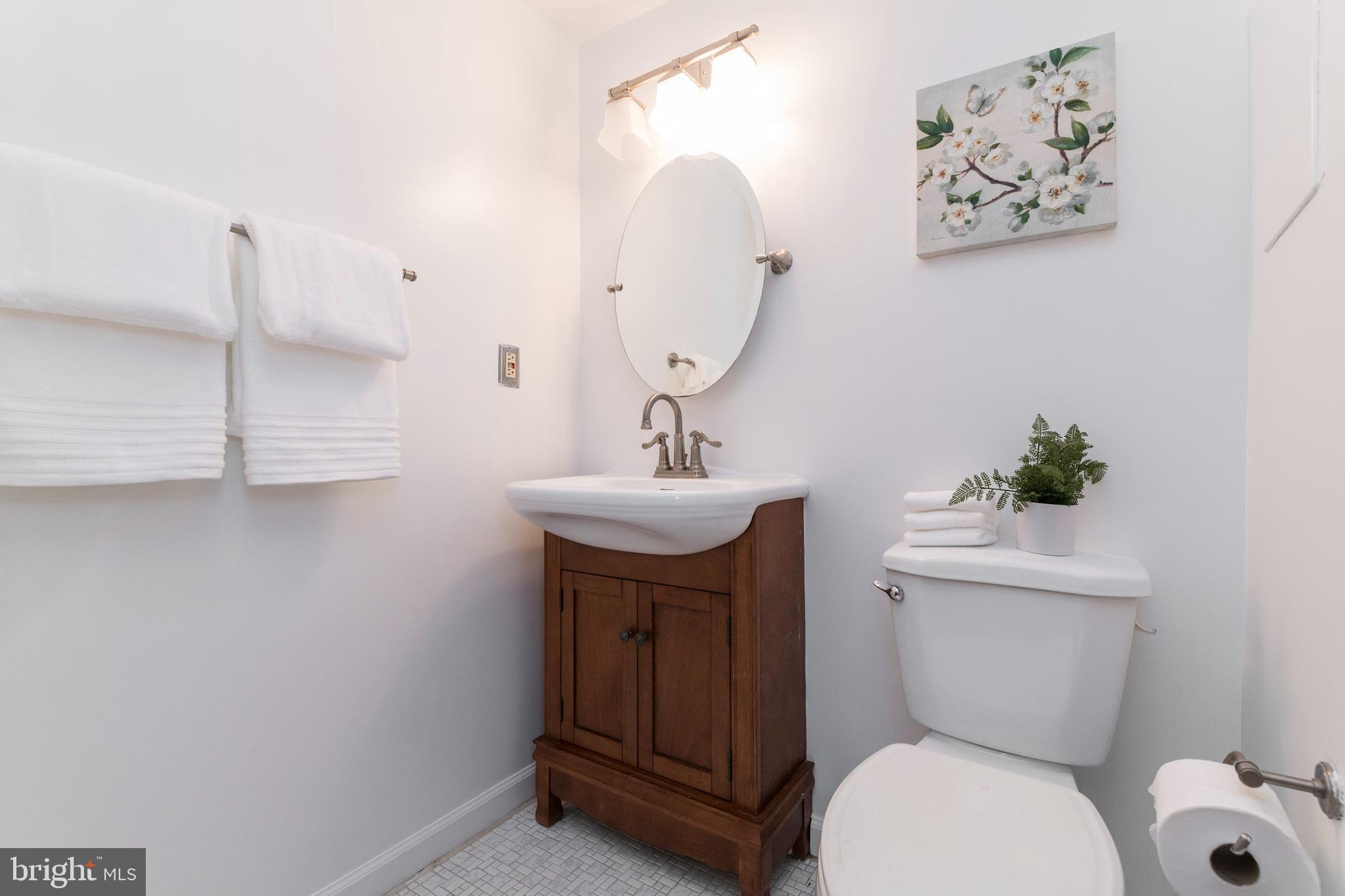 18 Stone Ridge Court, Unit 23 Baltimore, MD 21239 - Photo 18 of 19 a bathroom with a toilet a sink and mirror