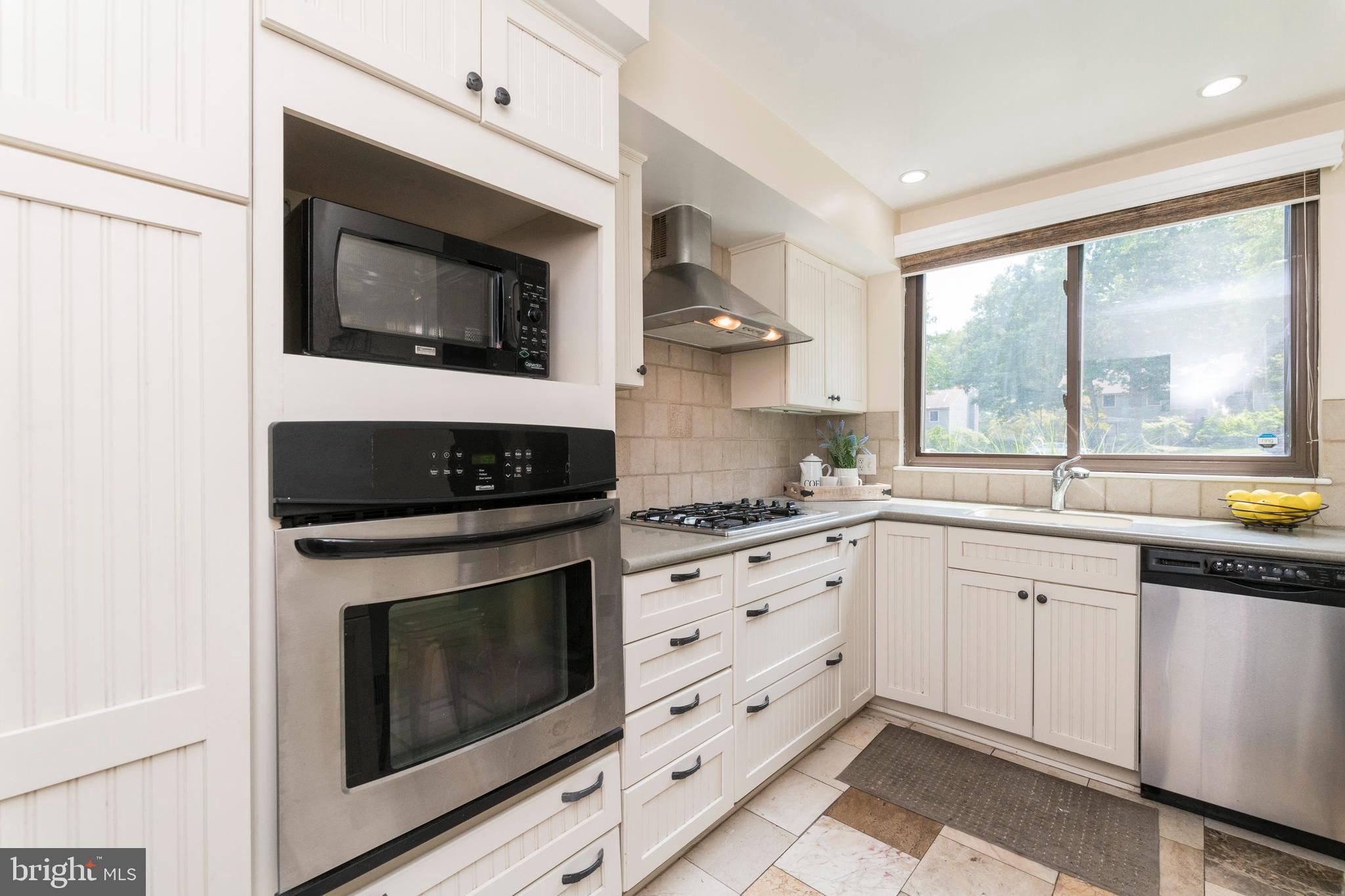 18 Stone Ridge Court, Unit 23 Baltimore, MD 21239 - Photo 9 of 19 a kitchen with granite countertop white cabinets stainless steel appliances and sink