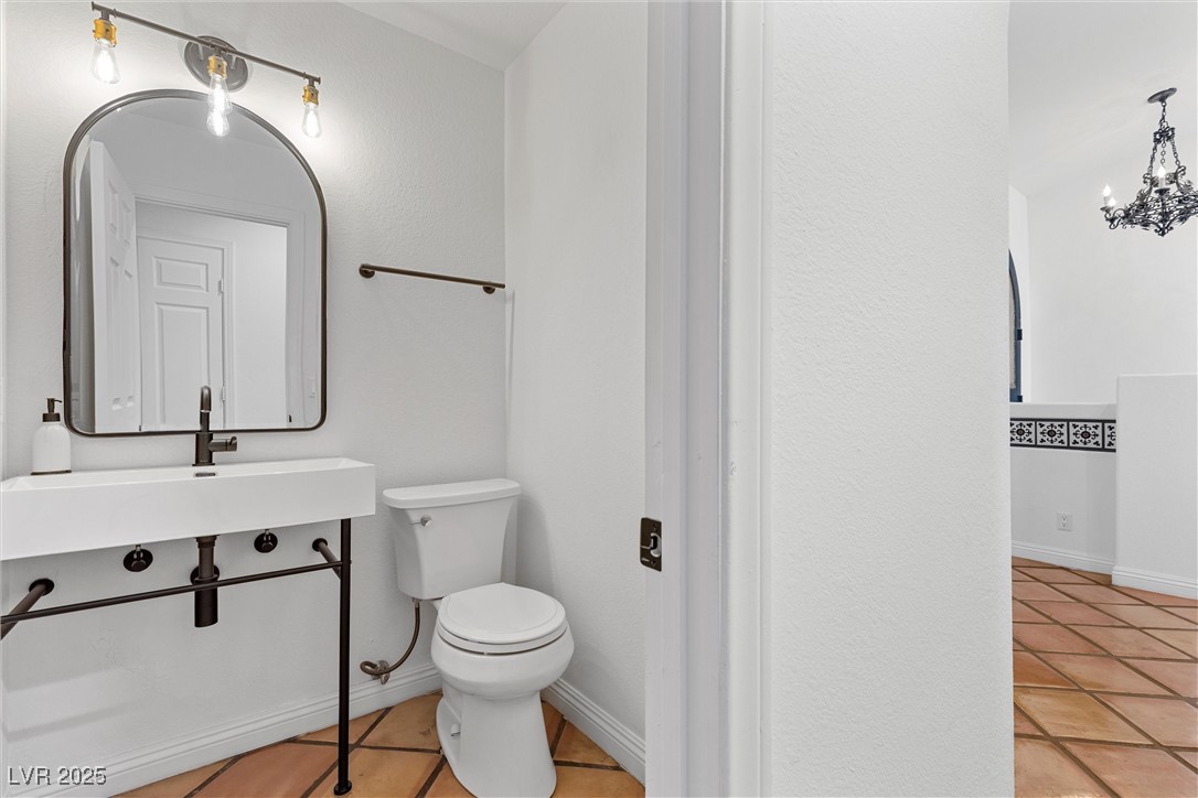 5555 West Desert Inn Road Las Vegas, NV 89146 - Photo 26 of 50 Half bathroom with charming mirror and upgraded light fixture.