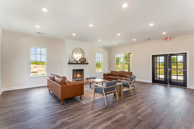 a dining room with wooden floor a glass table and chairs