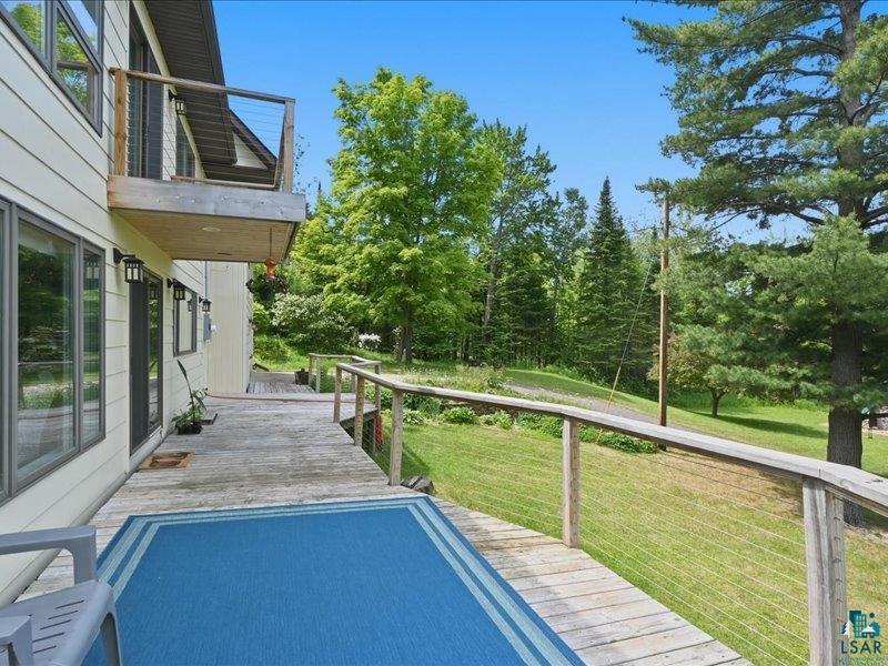 88440 Huron Street Cornucopia, WI 54827 - Photo 33 of 44 Expansive exterior decking featuring wood-finish flooring and cable rail system.