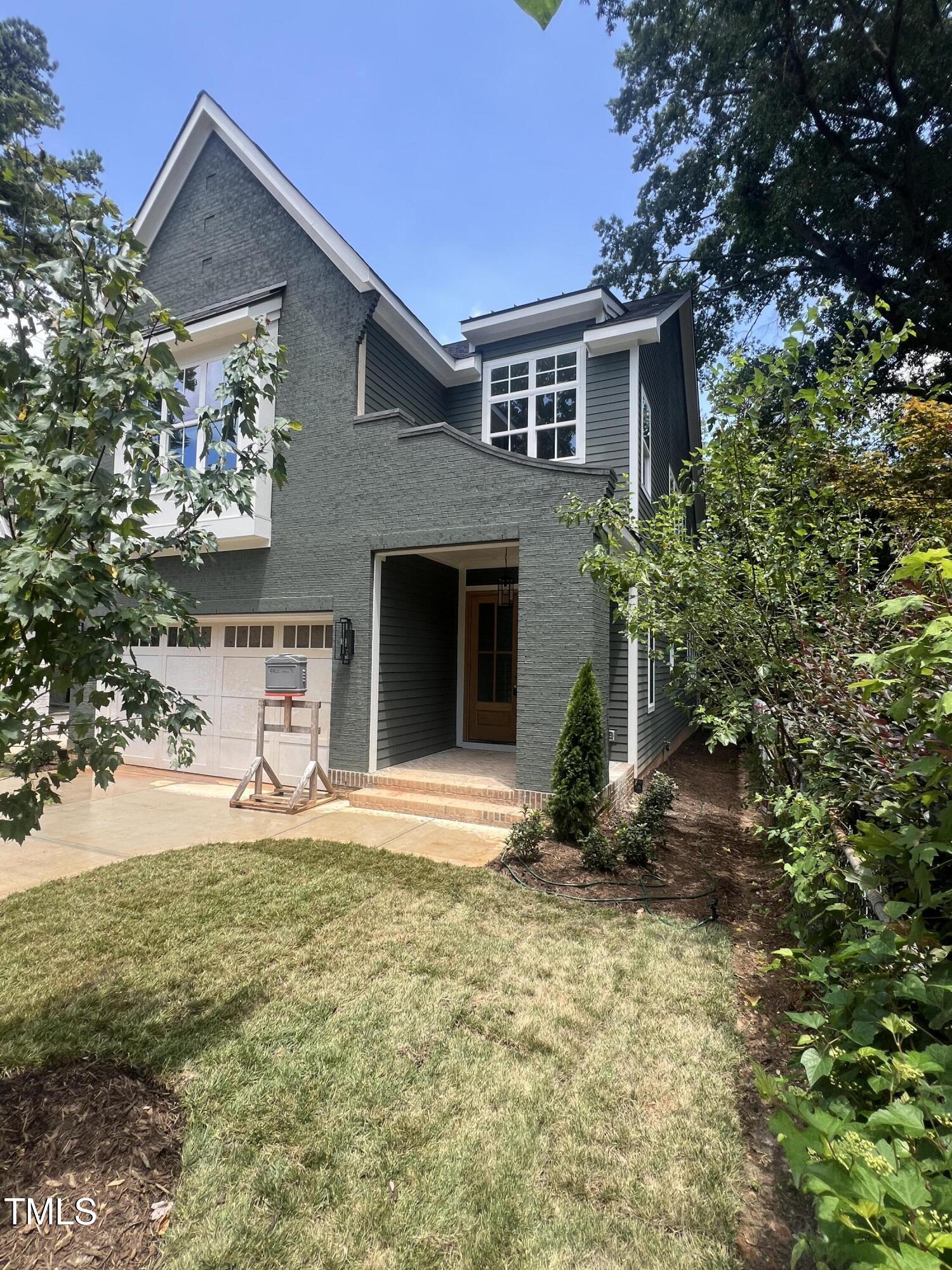 3302 Hall Place Raleigh, NC 27607 - Photo 2 of 25 a front view of a house with a yard and garage