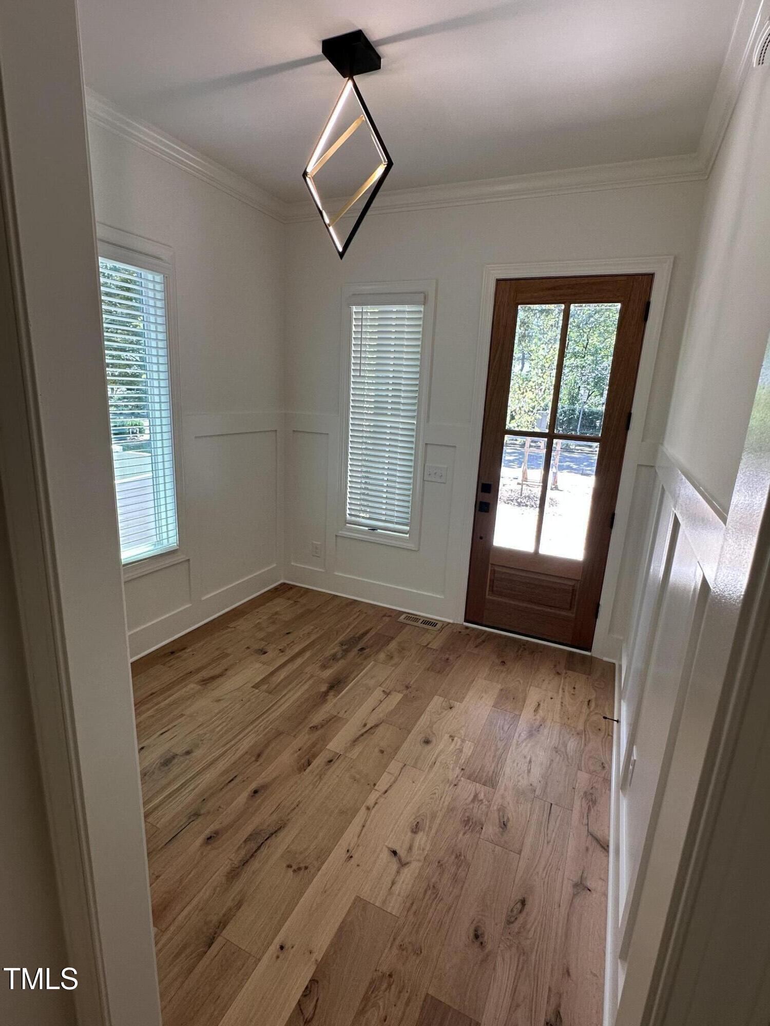 3302 Hall Place Raleigh, NC 27607 - Photo 4 of 25 a view of an empty room with wooden floor and a window