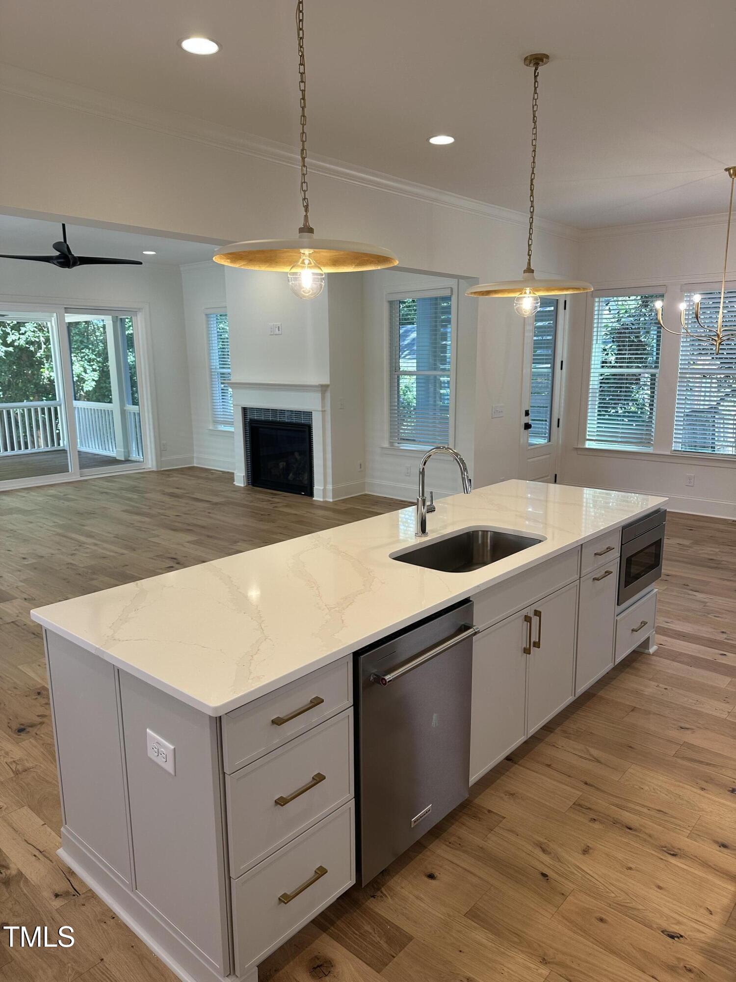3302 Hall Place Raleigh, NC 27607 - Photo 9 of 25 a large kitchen with kitchen island a large island wooden floor and a chandelier