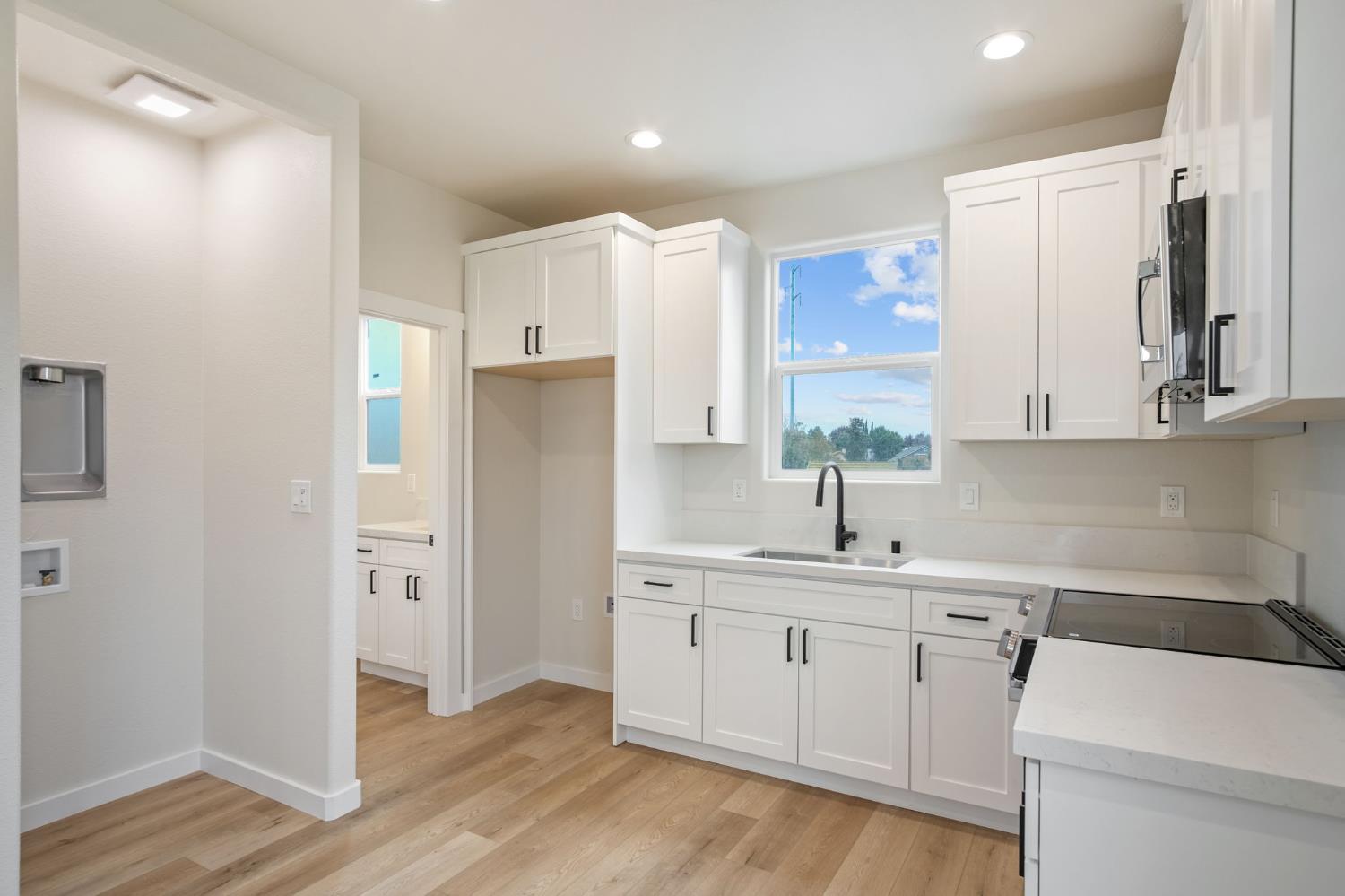 243 East E 3rd Street Tracy, CA 95376 - Photo 13 of 29 a kitchen with a sink dishwasher a refrigerator and wooden cabinets