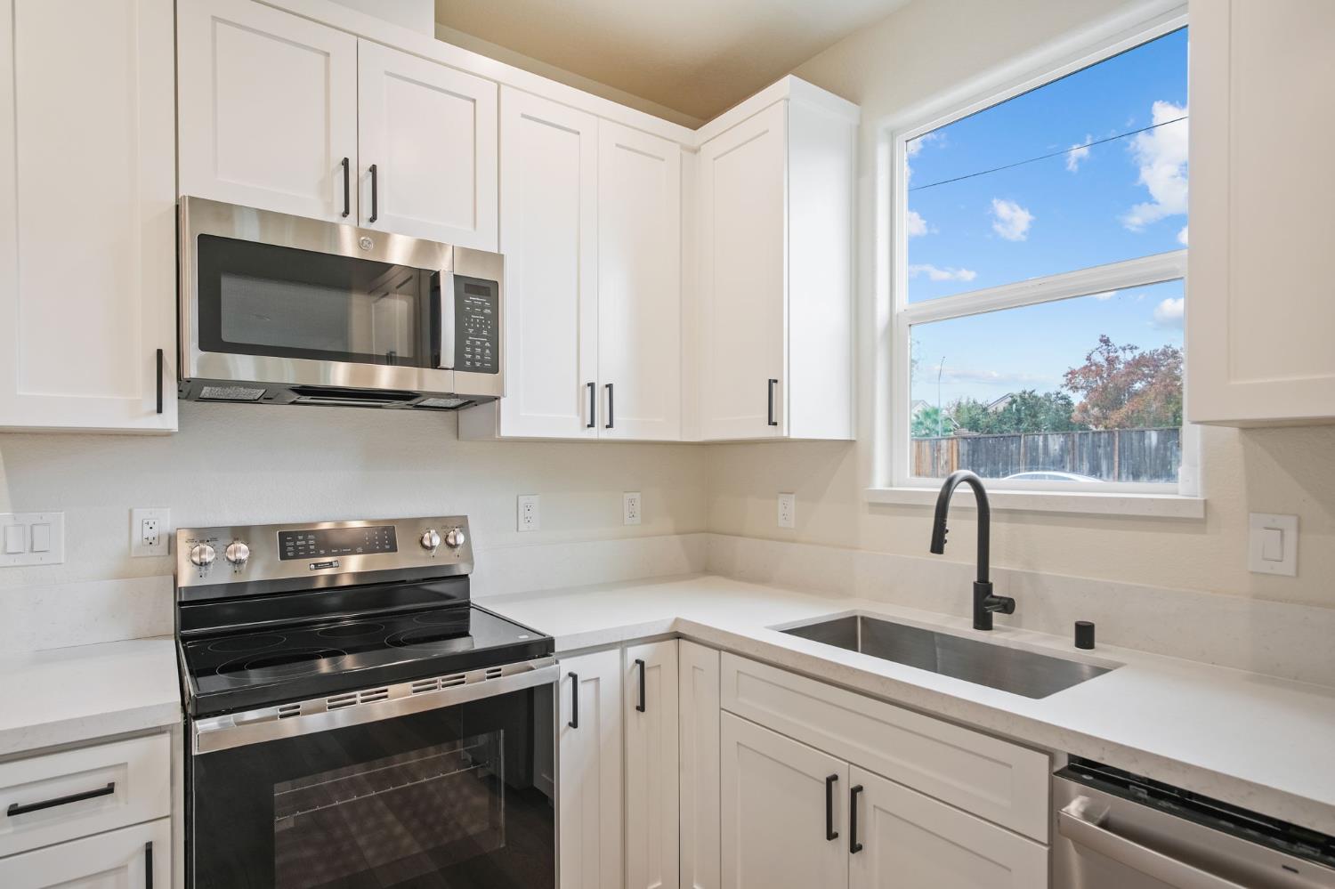 243 East E 3rd Street Tracy, CA 95376 - Photo 26 of 29 a kitchen with stainless steel appliances a stove a sink and a microwave
