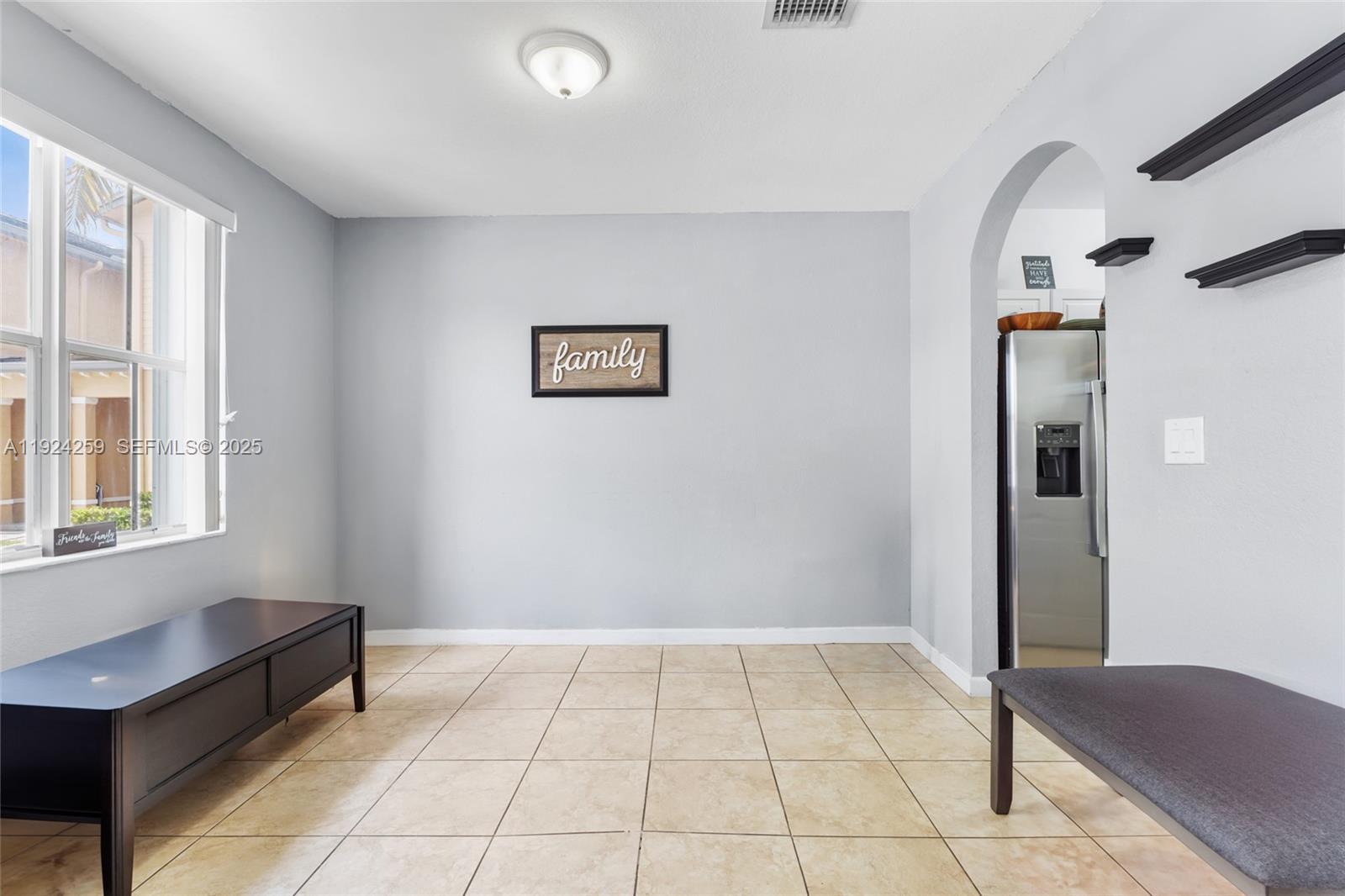 230 Southeast 29th Avenue, Unit 12 Homestead, FL 33033 - Photo 3 of 29 a view of an empty room with window and chandelier