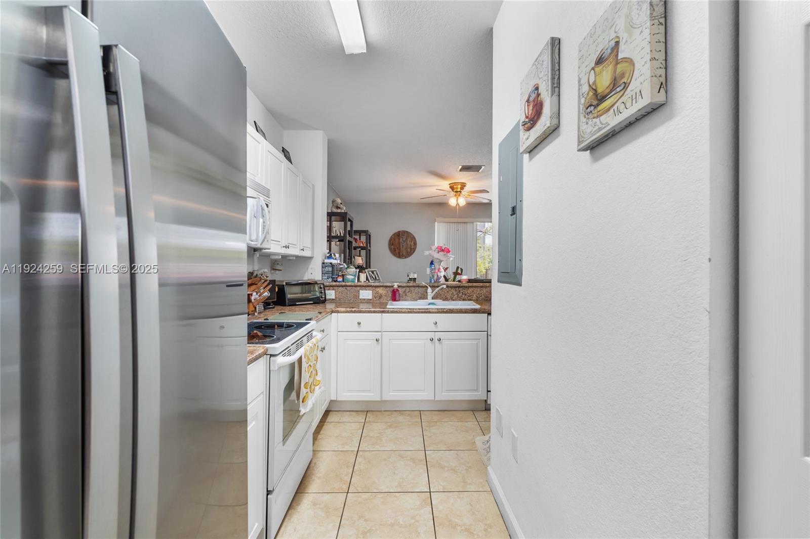 230 Southeast 29th Avenue, Unit 12 Homestead, FL 33033 - Photo 6 of 29 a kitchen with stainless steel appliances granite countertop a refrigerator and a stove top oven