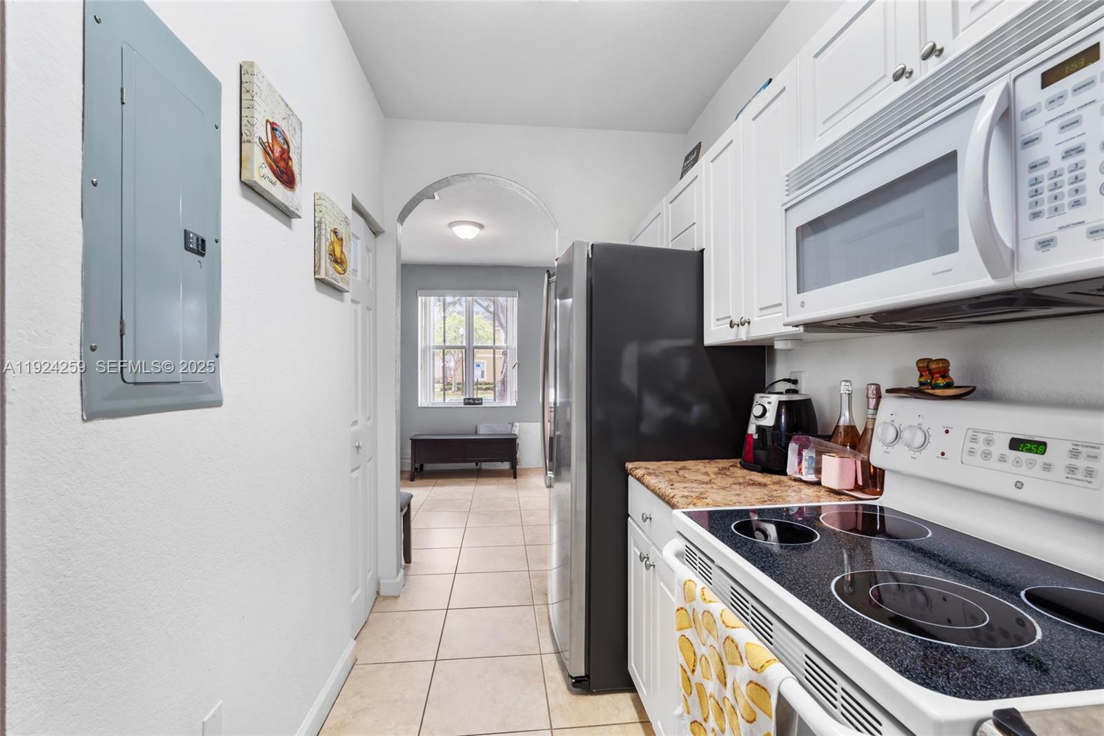 230 Southeast 29th Avenue, Unit 12 Homestead, FL 33033 - Photo 7 of 29 a kitchen with stainless steel appliances granite countertop a stove a refrigerator and a sink with wooden cabinets