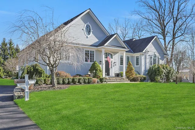 a front view of a house with a garden and trees