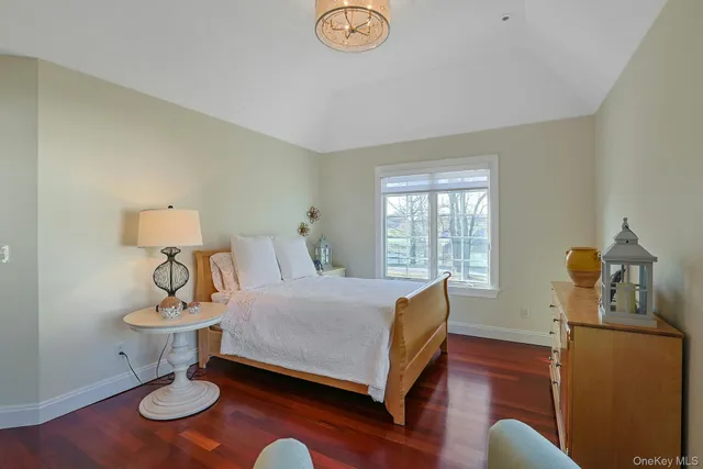 a bed sitting in a spacious bedroom next to a window