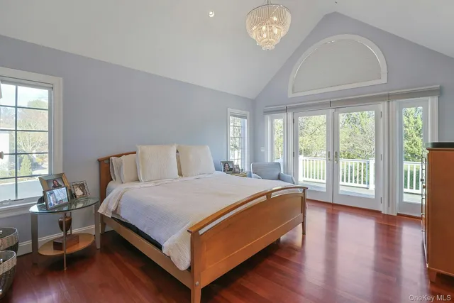a bedroom with a bed and a flat tv screen on dresser