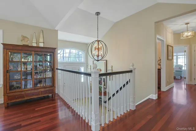 a view of a hallway with wooden floor and windows