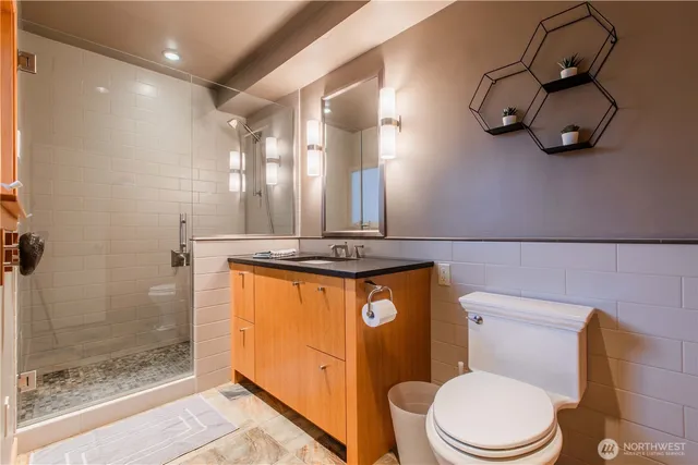a bathroom with a granite countertop toilet sink and mirror