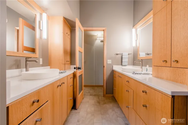 a large bathroom with a double vanity sink and mirror with shower