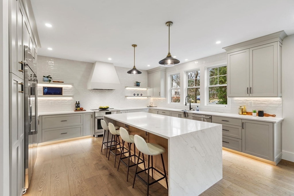 a large kitchen with kitchen island a large counter space and stainless steel appliances