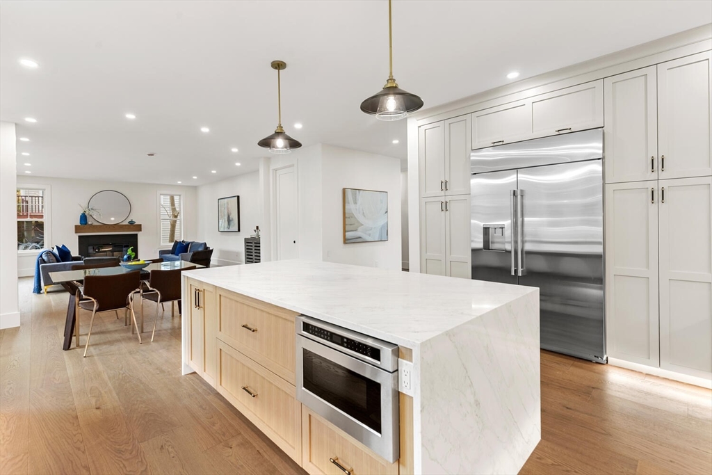 16 Estabrook Road Lexington, MA 02421 - Photo 13 of 38 a large kitchen with kitchen island a stove a sink a refrigerator and a dining table with wooden floor