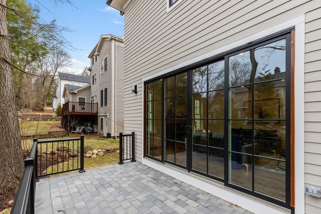16 Estabrook Road Lexington, MA 02421 - Photo 38 of 38 a view of a porch with a table and chair and floor to ceiling window