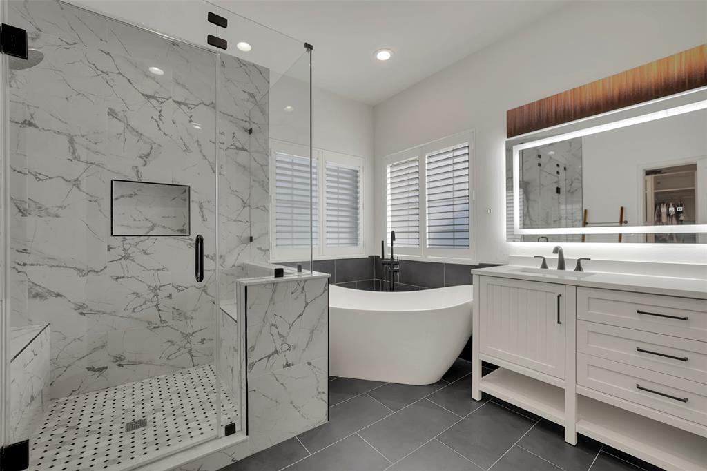 1690 Lynn Lane Lucas, TX 75002 - Photo 18 of 40 a bathroom with a sink a bathtub a mirror a vanity and a shower