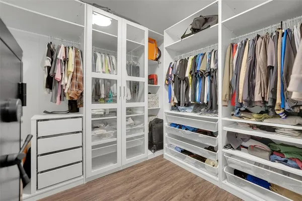 a view of walk in closet with clothes and shoes