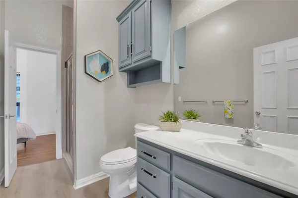 a bathroom with a granite countertop toilet sink and mirror