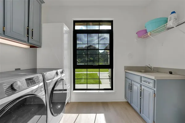 a utility room with cabinets washer and dryer