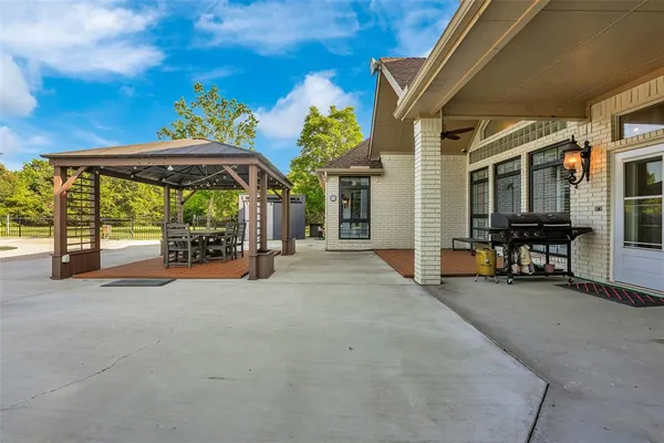 a view of a patio with a table and chairs under an umbrella
