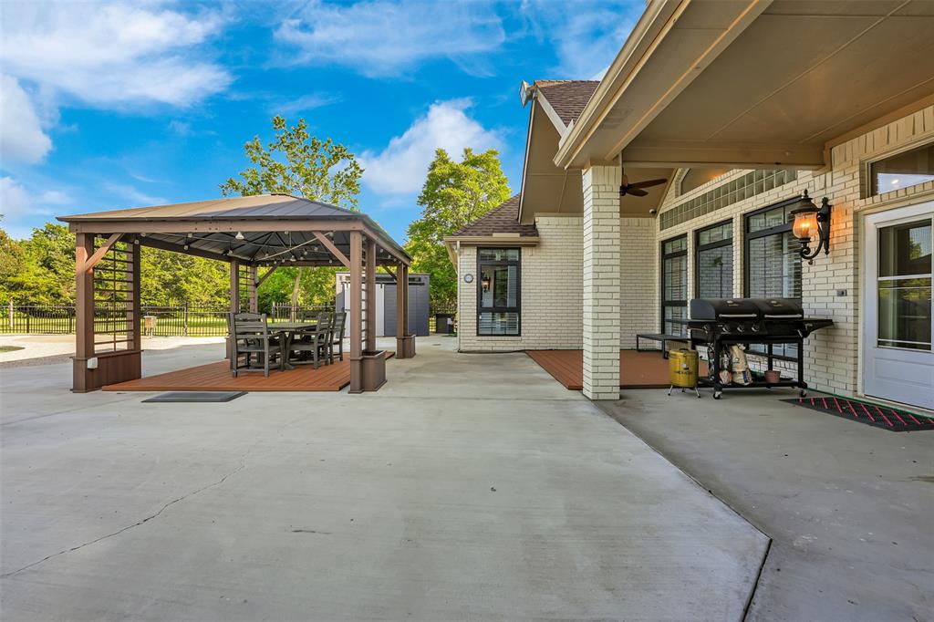 1690 Lynn Lane Lucas, TX 75002 - Photo 30 of 40 a view of a patio with a table and chairs under an umbrella
