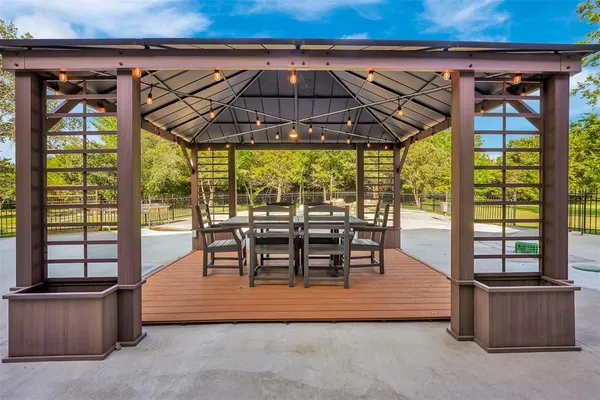 an outdoor sitting area with furniture and umbrella
