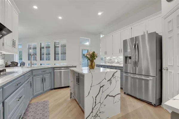 a kitchen with stainless steel appliances granite countertop a refrigerator and a sink