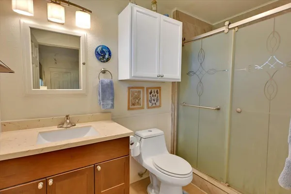 a bathroom with a sink a toilet and shower