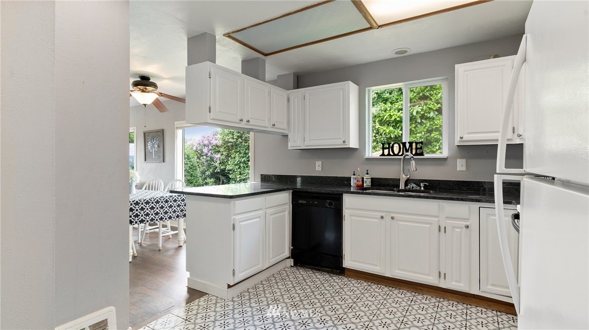 508 Southwest 3rd Place Renton, WA 98057 - Photo 7 of 23 a kitchen with granite countertop white cabinets white appliances a sink and a window