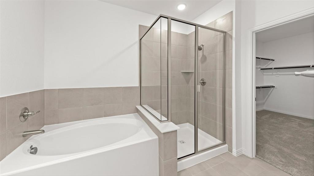 2747 Teton Street Corinth, TX 76210 - Photo 19 of 22 a bathroom with a bathtub and a shower