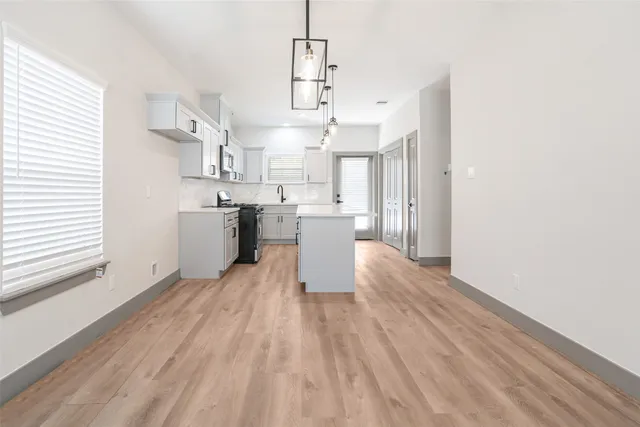 a large kitchen with cabinets wooden floor and stainless steel appliances