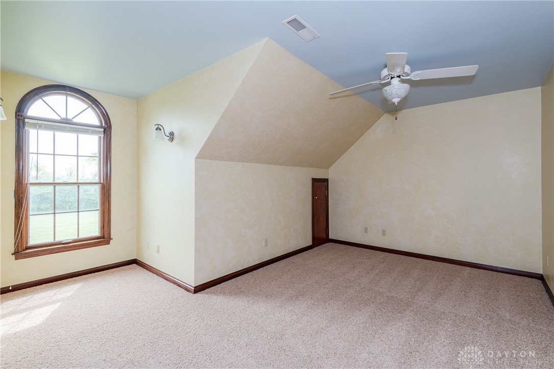 9981 Ridge Acres Lane Englewood, OH 45322 - Photo 28 of 73 This spacious bedroom features a captivating arched window, providing ample natural light and charm.