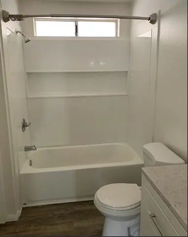a bathroom with a granite countertop sink mirror and toilet