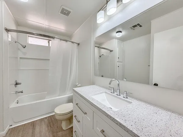 a bathroom with a granite countertop sink toilet and shower