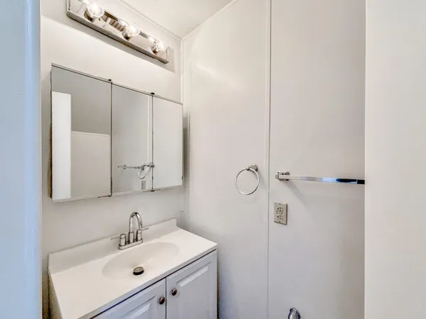 a bathroom with a sink mirror and shower